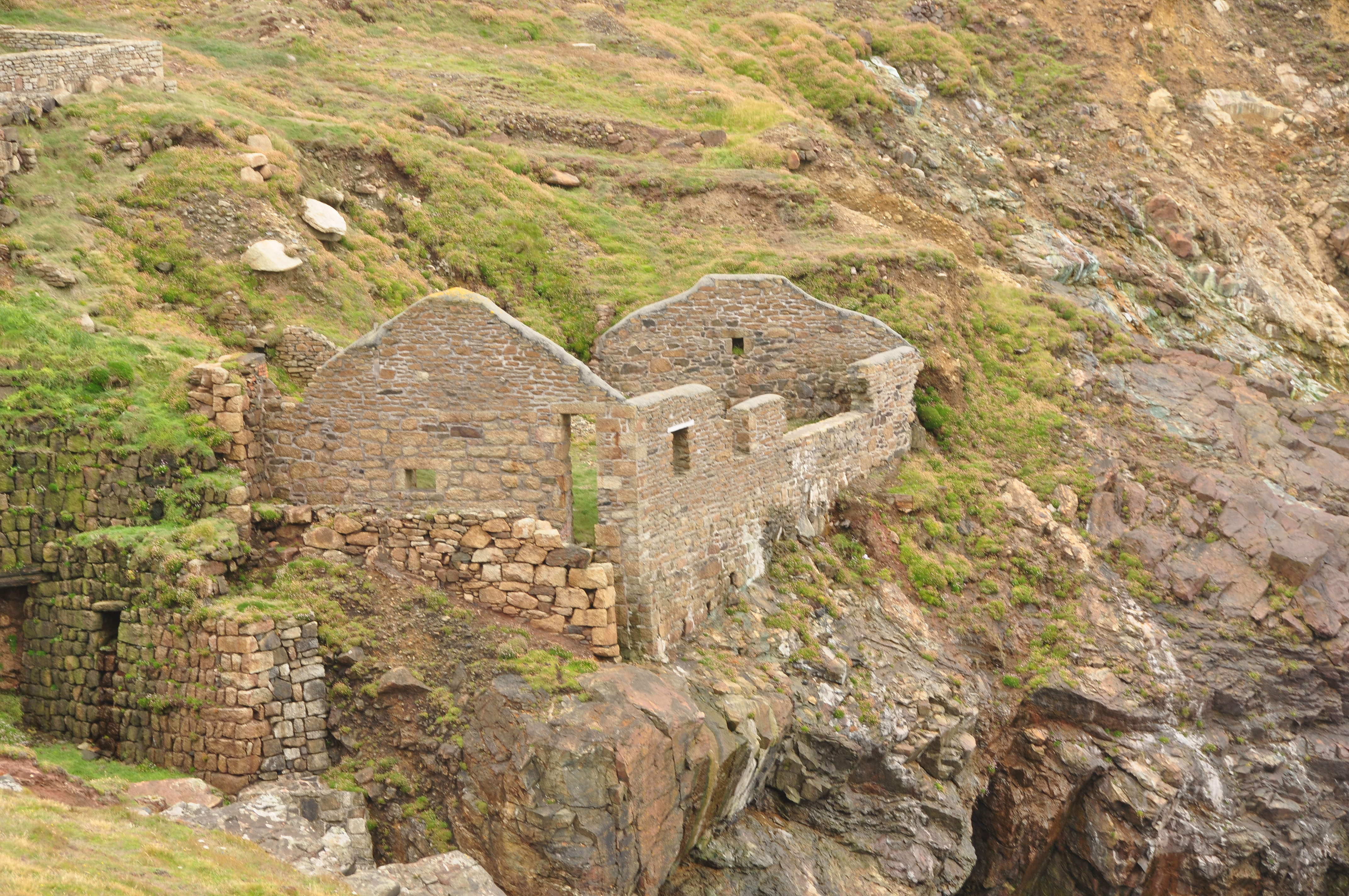 A roofless mine building below Geevor